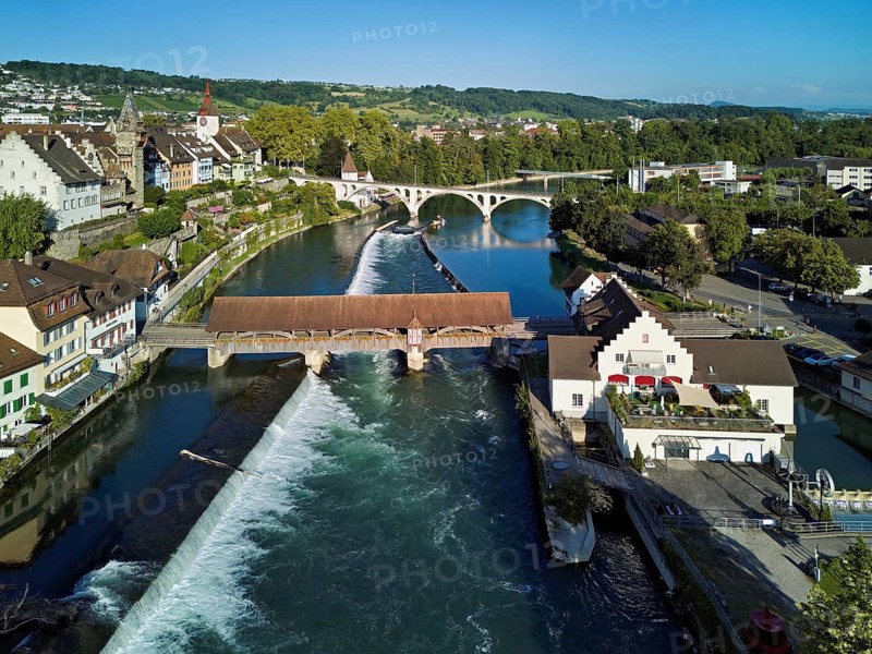 Old town with the tower of the Muri- Amthof, in the foreground the weir and the old wooden bridge crossing the river Reuss, on the right the museum Reusskraftwerk Bruggmühle, Bremgarten, Freiamt, Canton, Aargau, Switzerland