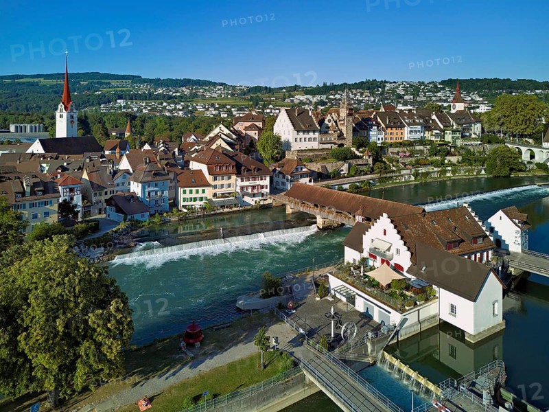 Old town with the Catholic Church of St Nicholas and the tower of the Muri- Amthof, in the foreground the weir and the museum Reusskraftwerk Bruggmühle on the river Reuss, Bremgarten, Freiamt, Canton, Aargau, Switzerland