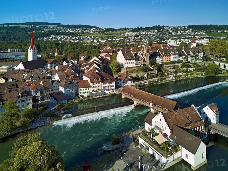 Old town with the Catholic Church of St Nicholas and the tower of the Muri- Amthof, in the foreground the weir and the museum Reusskraftwerk Bruggmühle on the river Reuss, Bremgarten, Freiamt, Canton, Aargau, Switzerland
