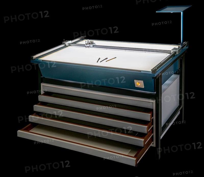 Illuminated layout table with open drawers isolated in black back