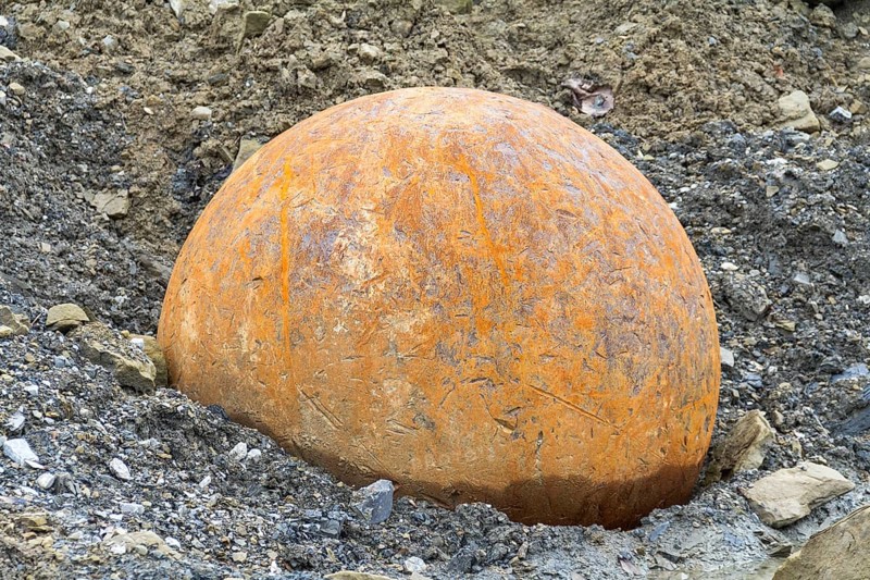 Rusty metal ball used for stone crushing in stony back