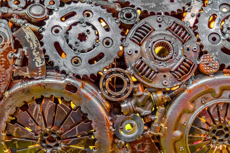 Full frame warm illuminated metallic mechanical background with gear wheels and other material