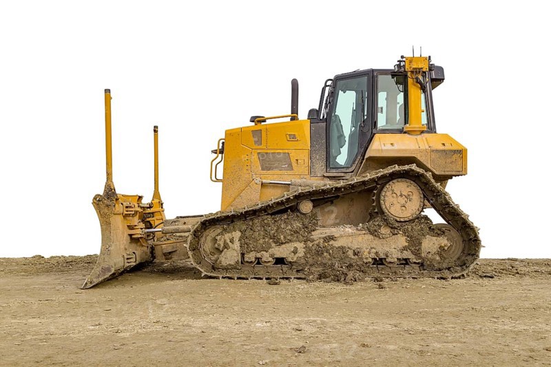 Yellow bulldozer at a loamy construction site, partly isolated in white back