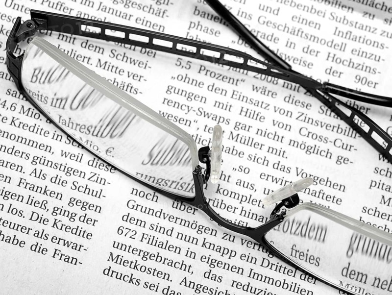 Newspaper detail with pair of glasses