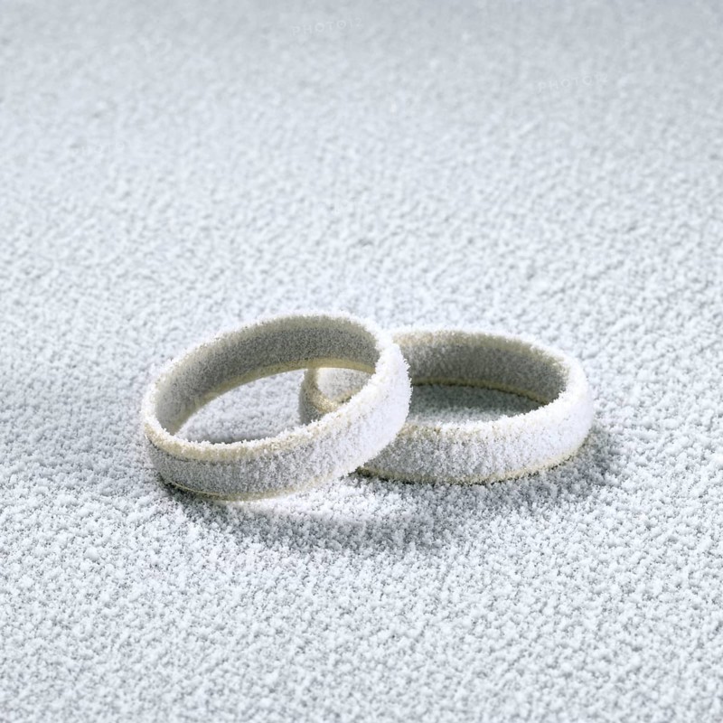 Studio photography of two frosted wedding rings in cold ambiance