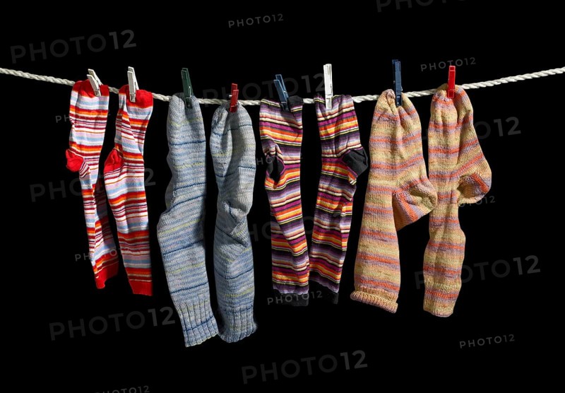 Clothesline with some multicolored sox fixed with clothes pins in black back