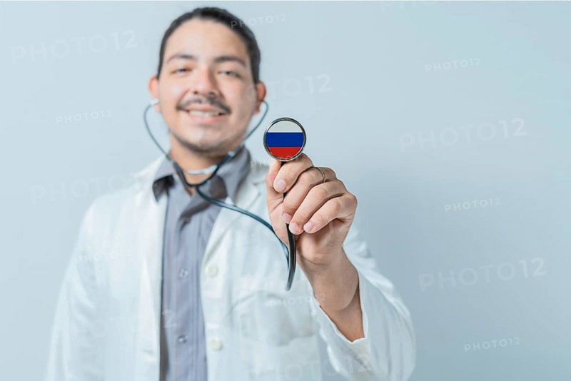 Smiling doctor showing stethoscope with Russia flag. Russia national healthcare