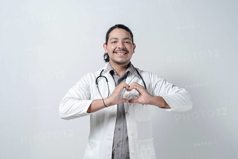 Smiling doctor making heart symbol on isolated