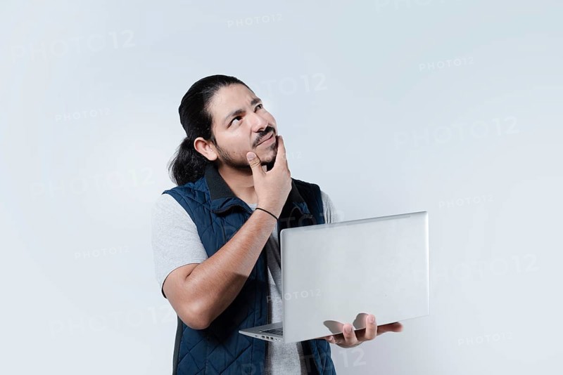 Thoughtful man with hand on chin using computer on isolated background. Man thinking holding a laptop on white background