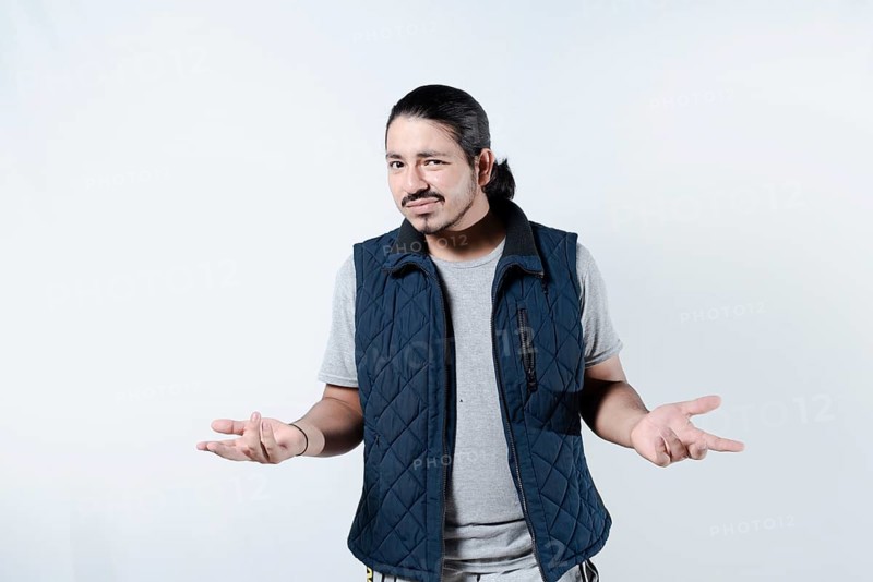 Confused young man with arms at his sides. Young male gesturing confusion on isolated background
