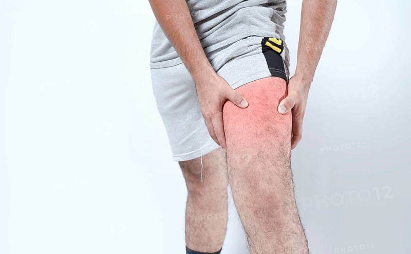 Closeup of sore knee on isolated background. Male holding his knee in pain on isolated