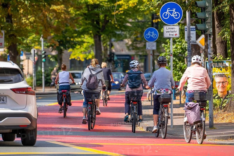 Cycle traffic in Münster, Warendorf Straße, broadly marked red asphalt as cycle path, cycle lane, colour-coded separated from the lane for cars, city centre of Münster, North Rhine-Westphalia, Germany