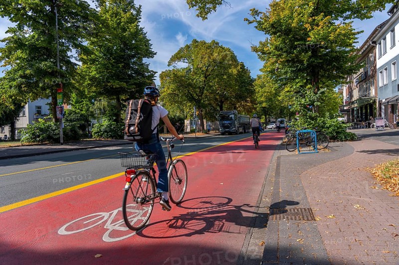 Cycle traffic in Münster, Warendorf Straße, broadly marked red asphalt as cycle path, cycle lane, colour-coded separated from the lane for cars, city centre of Münster, North Rhine-Westphalia, Germany
