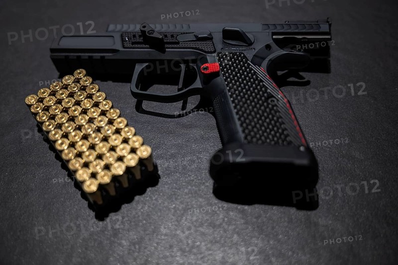 Modern Elegant Sport Handgun with Gas Pedal and Skirt and Bullet on Grey Background in Switzerland