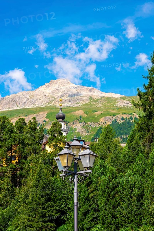 Church Tower and Street Lamp in the Forest and Mountain in the Swiss Alps in a Sunny Summer Day in Engandine, Maloja, Celerina, Schlarigna, Grisons, Switzerland