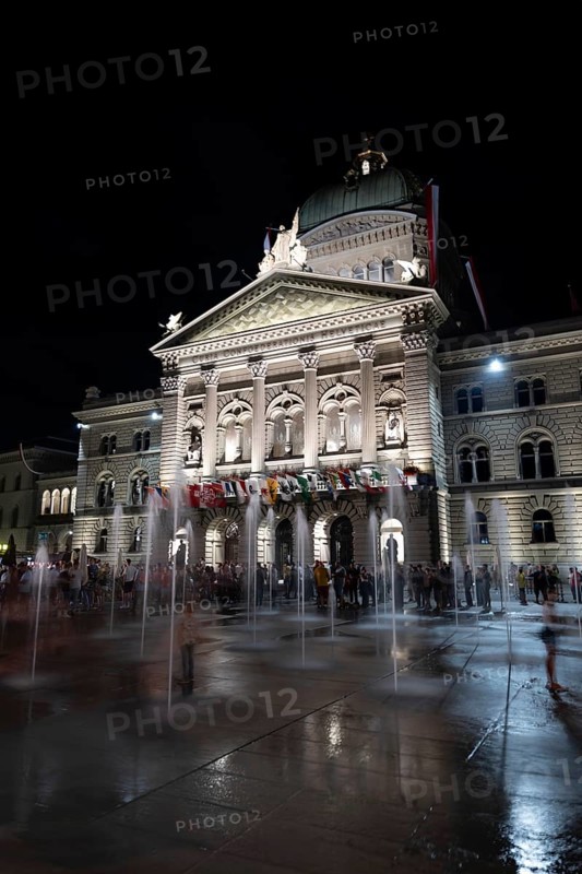 Beautiful Bundeshaus Illuminated Parliament Building or Federal Palace with Water Fountain on Bundesplatz at Night in City of Bern, Bern Canton, Switzerland