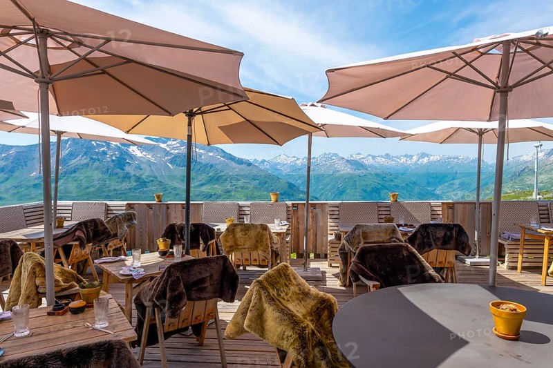 View From a Restaurant Terrace with Parasol and with Mountain Peak in the Swiss Alps and Sky in a Sunny Summer Day in Andermatt, Uri, Switzerland