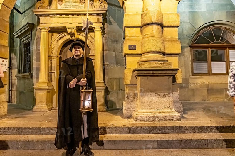 The night watchman in front of the town hall at dusk, Rothenburg ob der Tauber at dusk, Bavaria, Germany