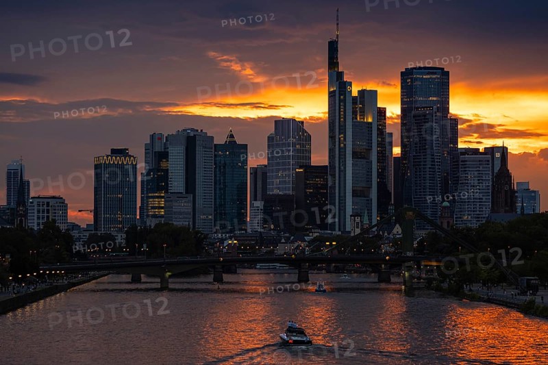 The sun breaks through the clouds behind the Frankfurt banking skyline shortly in front of setting, Frankfurt am Main, Hesse, Germany