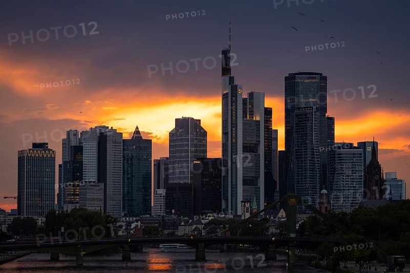 The sun breaks through the clouds behind the Frankfurt banking skyline shortly in front of setting, Frankfurt am Main, Hesse, Germany