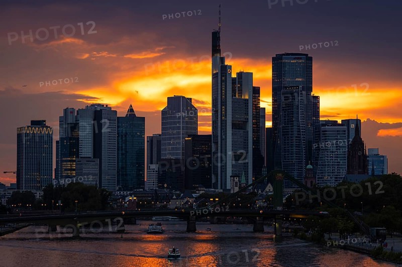 The sun breaks through the clouds behind the Frankfurt banking skyline shortly in front of setting, Frankfurt am Main, Hesse, Germany