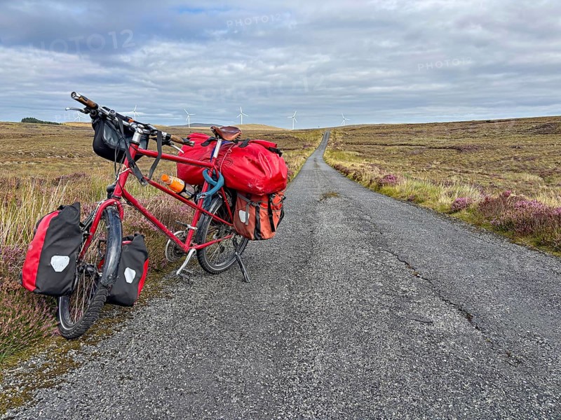 A fully loaded bicycle stands on a long country road in a wide landscape, Adventure, Cycling tour, Isle of Lewis Hebrides, Scotland, Great Britain