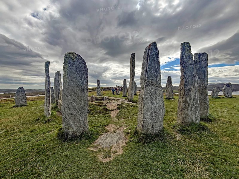 A mystical stone circle under a cloudy sky surrounded by green landscape, Callanish, Isle of Lewis Hebrides, Scotland, United Kingdom