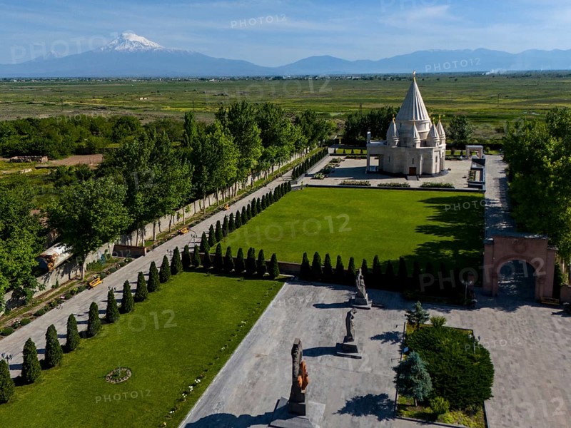 A picturesque landscape with a temple and mountains in the background under a blue sky, aerial view, Yazidi temple, the largest Yazidi temple in the world is called Quba Mere Diwane, Aknalich, Aknalitsch, Armavir district, in the background Mount Aarat in Turkey, Armenia