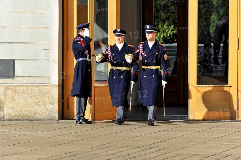 Changing of the guard at Prague Castle, Hradcany, Prague, Czech Republic, Europe, Soldiers in blue uniforms leave a building through large wooden doors