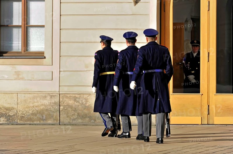 Changing of the guard at Prague Castle, Hradcany, Prague, Czech Republic, Europe, Three soldiers in uniform march towards a large wooden gate