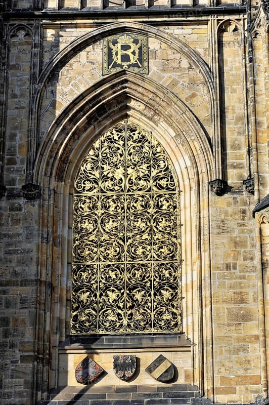 St Vitus or St Vitus Cathedral, Hradcany, Prague, Czech Republic, Europe, Barred Gothic window with rich decorations and coats of arms in the sunshine