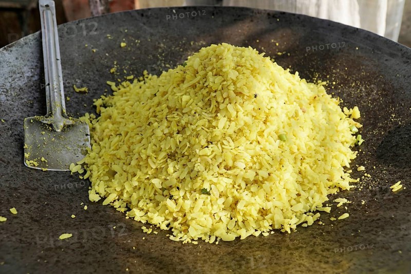 Kota, Rajasthan, North India, Asia, A large pile of poha in an iron pan with a spatula next to it, India