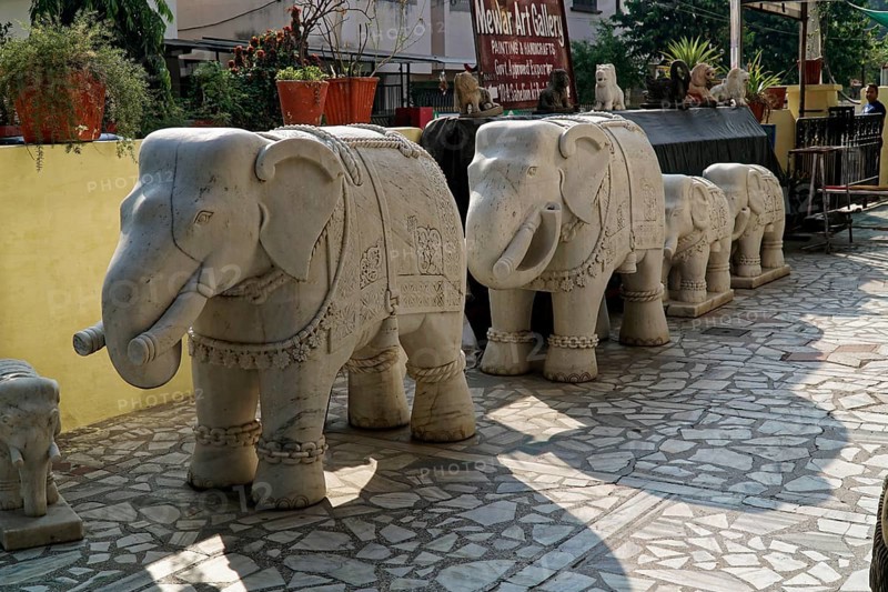 Udaipur, Rajasthan, North India, India, Asia, Row of stone elephant sculptures in an art gallery in daylight