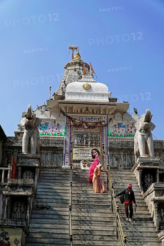Entrance to Jagdish Temple, Udaipur, People climb the steps to a temple flanked by statues under a clear sky, Rajasthan, North India, India, Asia, An important temple with monumental stairs and a spiritual attraction