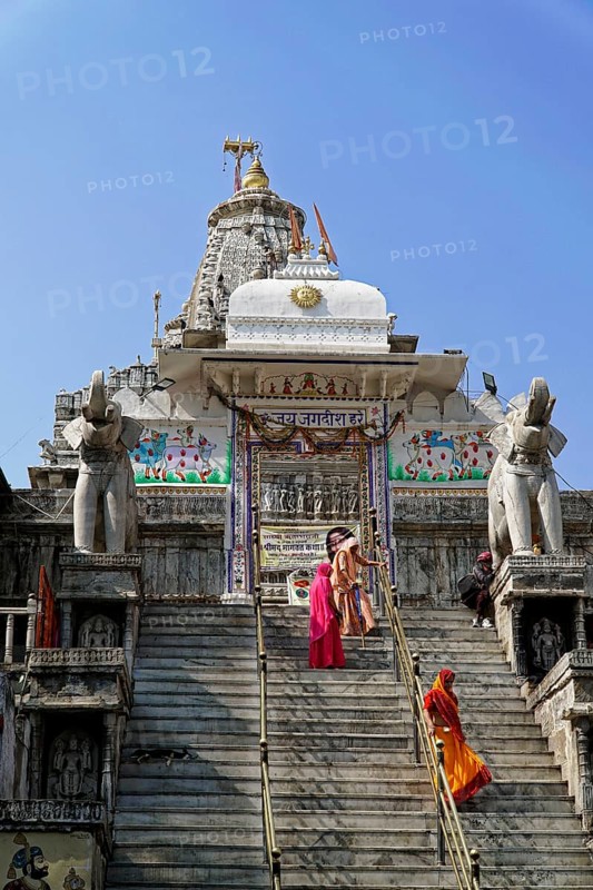 Entrance to Jagdish Temple, Udaipur, people climb the steps to a temple flanked by statues under a clear sky, Rajasthan, North India, India, Asia, Temple with ornate decorative elements and elephant sculptures