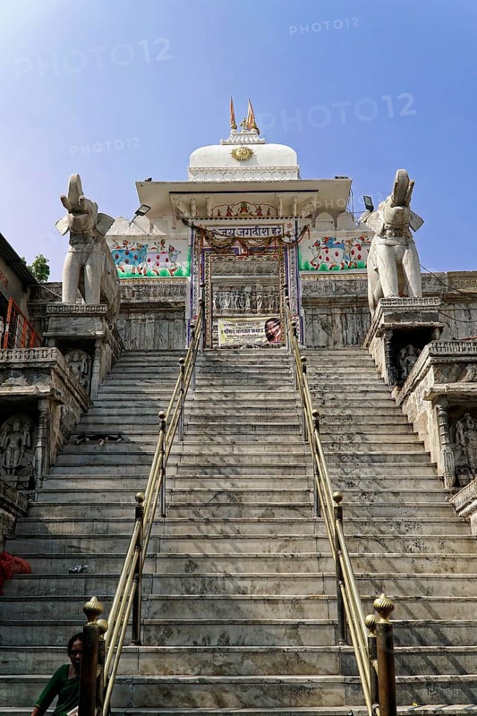 Entrance to Jagdish Temple, Udaipur, People climb the steps to a temple flanked by statues under a clear sky, Rajasthan, North India, India, Asia, An impressive temple with long marble steps and elephant statues under a clear blue sky