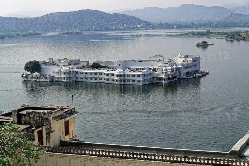 Lake Pichola overlooking Lake Palace, Udaipur, Rajasthan, India, Asia, Palace on a lake surrounded by hills and water in a tranquil setting, North India
