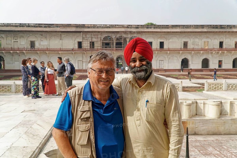Red Fort, Agra, Uttar Pradesh, India, Two men smile friendly in the historic courtyard while groups stand in the background, Jodhpur, Rajasthan, North India
