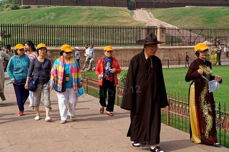 Group of tourists with yellow hats walking through a historical site, Agra, Jodhpur, Rajasthan, North India