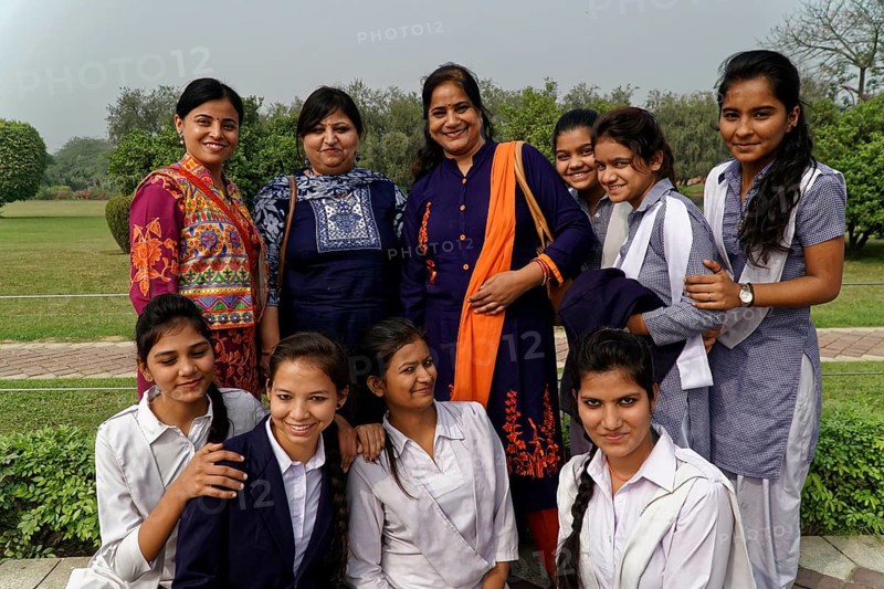 Group of female teachers and students in colourful clothes posing smiling outdoors, Agra, Jodhpur, Rajasthan, North India