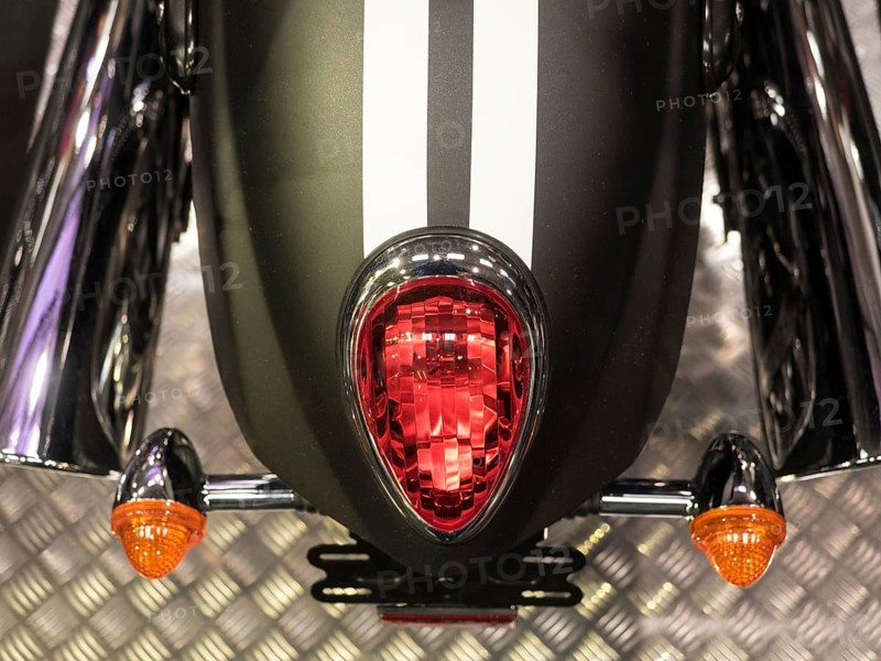 Black motorbike with red tail light and white stripes on metal floor, dortmund, deutchland