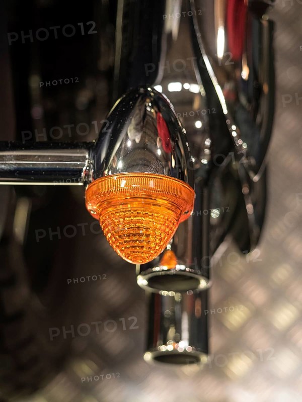 Close-up of an orange motorbike indicator with chrome details, dortmund, deutchland
