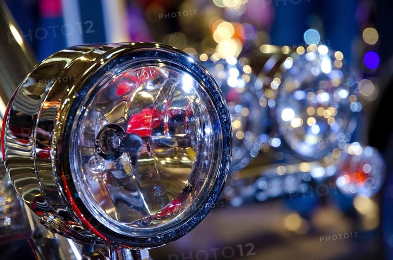 Shiny chrome headlights of a motorbike, surrounded by light reflections, dortmund, germany