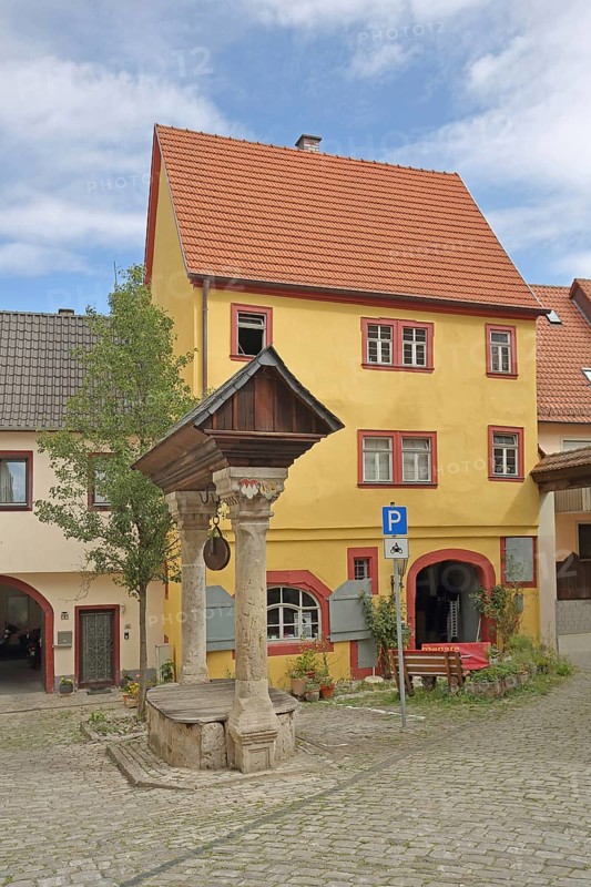 Historic council fountain built in 1583, draw well with columns and roof, house, Ochsenfurt, Lower Franconia, Franconia, Bavaria, Germany