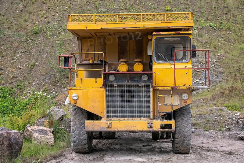 Yellow haul truck in a quarry at summer time