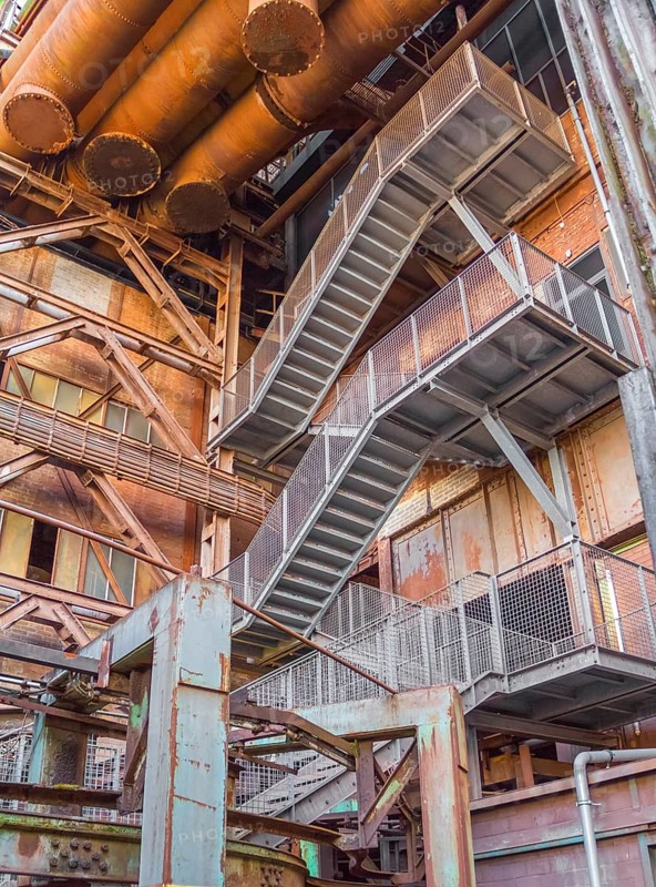 Low angle rusty industrial scenery with old corroded steel girders and metal tubes