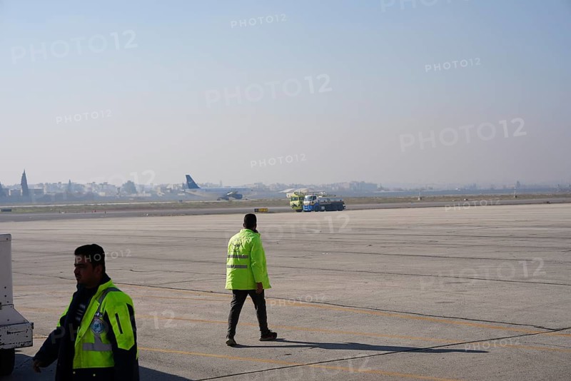 Passengers celebrate with Syrian revolutionary flags as the first flight lands at Aleppo International Airport in the presence of government officials following the fall of Bashar al-Assad's regime. Aleppo, Syria. December 18, 2024, Aleppo, Aleppo, Syria