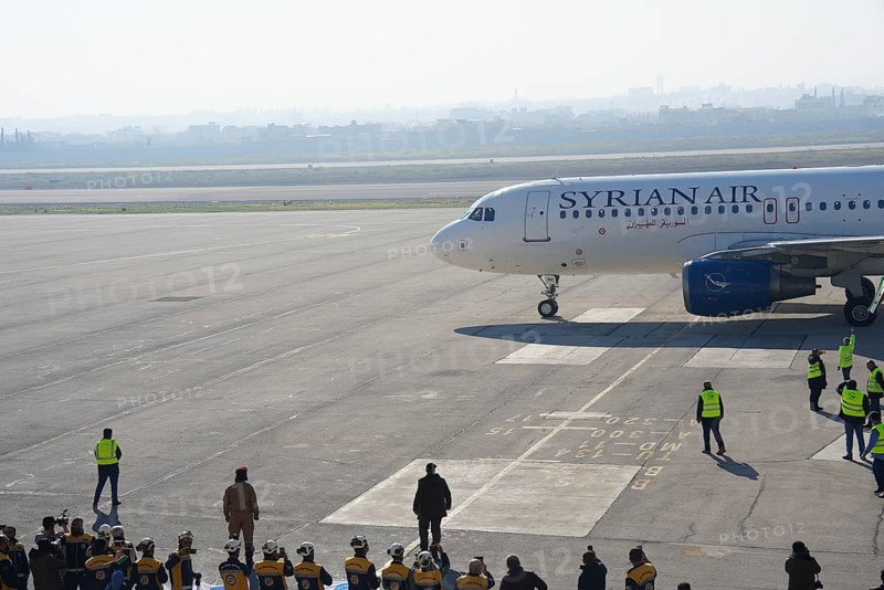 Syrians gather to welcome the first passenger plane to land at Aleppo International Airport following the fall of Bashar al-Assad's regime. Aleppo, Syria. December 18, 2024, Aleppo, Aleppo, Syria