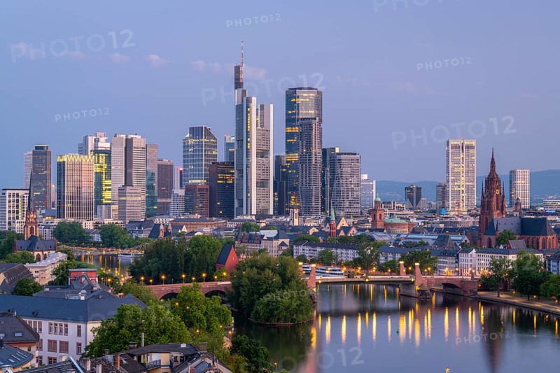 Illuminated Frankfurt City Skyline, Residential Buildings, Bridges and Main River at Morning Twilight. Aerial View. Blue Hour. Hesse, Germany