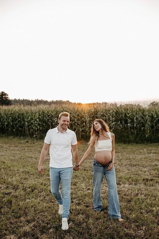 Pregnant young woman walks with her partner
